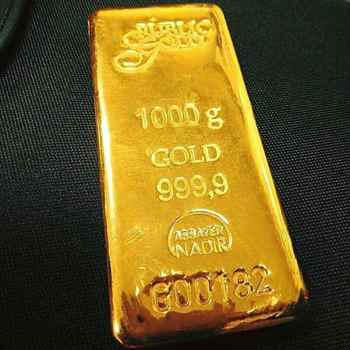 Emas batangan 1000 gram Public Gold di atas kain gelap, melambangkan simpanan emas rumah tangga masyarakat Indonesia