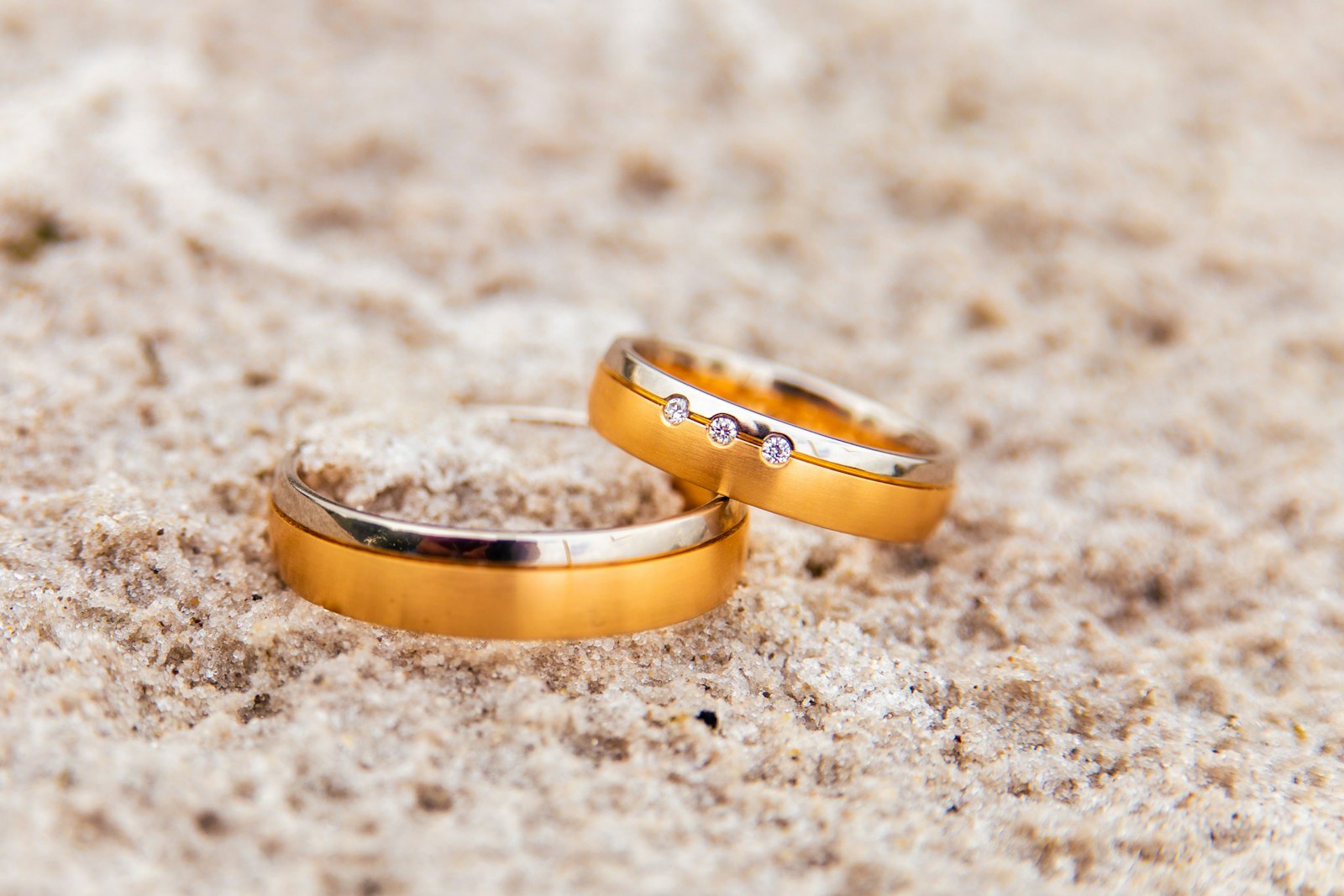Sepasang cincin pernikahan emas melambangkan komitmen keuangan pasangan baru menikah dalam menabung emas bersama
