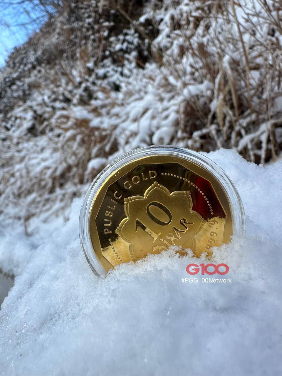 Koin emas Public Gold 10 Dinar di atas salju sebagai ilustrasi sedekah dan wakaf emas yang berkah